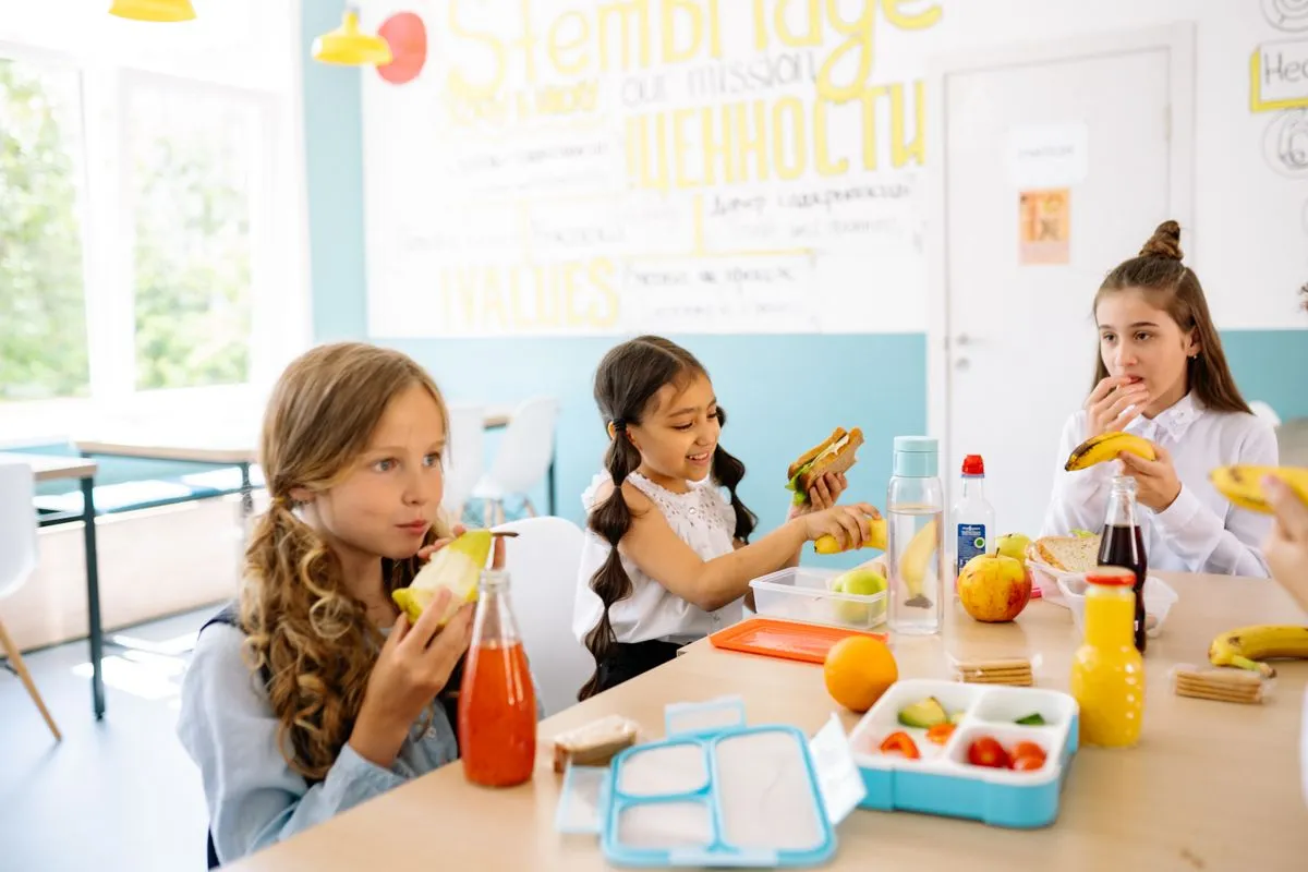 Kinder essen gemeinsam am Tisch in einer Betreuungseinrichtung